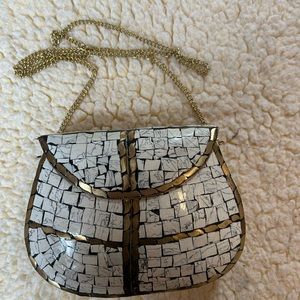 Handtiled handbag with gold chain.